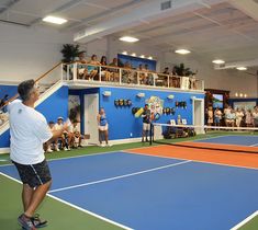 a man standing on top of a tennis court holding a racquet in his hand