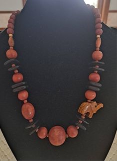 "This Vintage Boho African Style Necklace is made with all Wood Beads. It has several different sizes of Round Wood Beads and Black Disk Square Beads. It has one Carved Wooden Elephant Decoration. One of the brown beads, third down from the top has a hole drilled through it sideways. The Necklace measures  approx 24\" from end to end. It has a barrel clasp." African Style Necklace, Elephant Decoration, Wooden Elephant, Square Beads, Wood Bead Necklace, Elephant Decor, Jeweled Earrings, African Style, Square Bead