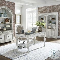 a white desk with a laptop on top of it in front of a brick wall