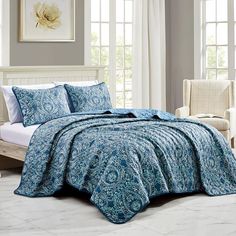 a bed in a bedroom with blue and white bedspread