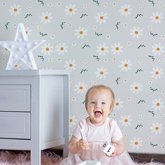 Introducing our enchanting "Summer Daisy Dream" flower wallpaper, designed to sprinkle a touch of whimsy into your little one's room. Featuring a playful array of white daisies with vibrant yellow centers, set against a soothing grey backdrop, this pattern evokes a field of summer flowers under a soft sky. The occasional green stems add a fresh, natural touch, perfect for sparking imagination and creativity in your child’s space. Transform any room into a delightful haven where dreams bloom and Dream Flower, Whimsical Nursery, Wallpaper Project, White Daisies, Wallpaper Rolls, Unique Wallpaper, Nursery Wallpaper, Dream Decor, Kid Spaces