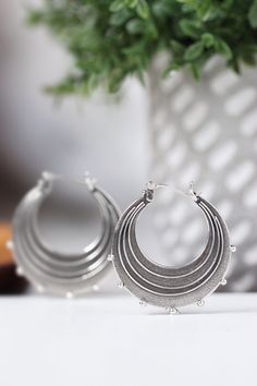 "Evocative of raindrops striking a pool of water, circles radiating outward from the point of impact and smaller droplets becoming airborne. These earrings are made completely of sterling silver, right down to the ear wires which are hinged and connect in a catch on the other side. The line and ball design is repeated on both sides of each earring. Each hoop measures approximately 1.25\" in diameter. The hoops have been given a patina to darken them and then tumbled in steel shot to give them a Metal Drop Hoop Earrings With Ear Wire, Nickel-free Metal Drop Hoop Earrings, Silver Hoop Chandelier Earrings, Raindrop Earrings, Earrings Silver Hoops, Ball Design, Earrings Round, Sterling Silver Hoop Earrings, Sterling Silver Hoops