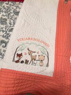 an orange and white quilted blanket with pictures of dogs on it that says, you are beloved