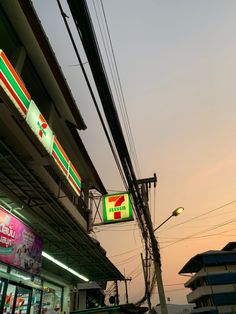 a green and red sign hanging from the side of a building next to a traffic light