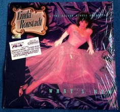 the album cover for what's new? by linda roustad, featuring an image of a woman in a pink dress