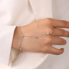 Add some sparkle to your everyday look! Delicate and elegant, this hand chain features zirconia crystals that will catch the light and shine with every movement. Perfect for dressing up any outfit, or as a unique addition to your jewelry collection. Metal: 925 sterling silver Finish: 18k gold Gemstone: white zirconia Bracelet length: adjustable with 4 cm extender (1.5") Chain: cable link Clasp: spring ring Hypoallergenic & nickel-free Don’t forget, proper care of your gold-plated jewelry will pr Elegant Metal Chain Ring For Gift, Elegant Silver Chain Ring With Diamond Accents, Adjustable Elegant White Gold Chain Ring, Elegant Adjustable White Gold Chain Ring, Elegant Cubic Zirconia Chain Ring For Formal Occasions, Elegant Cubic Zirconia Chain Ring Gift, Formal Cubic Zirconia Crystal Bracelet With Adjustable Chain, Silver Chain Bracelet For Party Fine Jewelry, Elegant Chain Ring With Diamond Accents In Cubic Zirconia