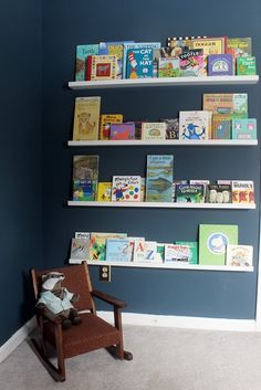 there are many books on the shelves in this child's room, and one chair is next to it