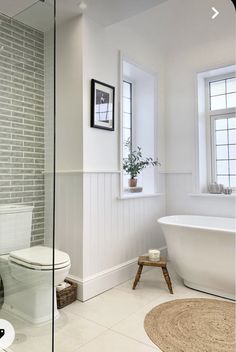 a bathroom with a toilet, tub and window