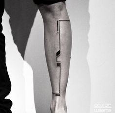 a black and white photo of a person's leg with a tattoo on it