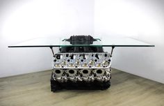 the engine block is sitting on top of a glass table in front of a white wall