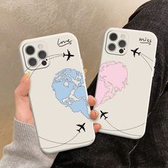 two people holding up their phone cases with the world in between them and an airplane on it