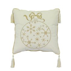 a white and gold christmas ornament pillow with tassels on the side