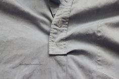 the collar of a blue shirt that is rolled up and unbuttoned with buttons