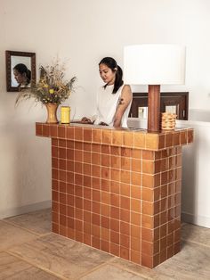 a woman standing at the front desk of a hotel