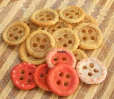 there are many different types of cookies on the table with one red and one white button