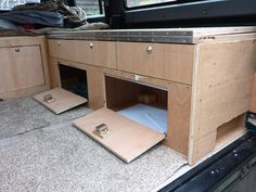 the inside of a van with wooden drawers and plywood flooring on it's sides