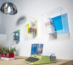 a desk with a typewriter, lamp and books on it