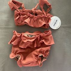 The Mini Cabana Bikini Set Is In Coral And Size 12-18 Months. Baby Size.A Take On Montce’s Classic Cabana Top But For Minis. We Hit All The Same Details- Created A Well-Made Bikini Set With Ruffle Detail, Cap Sleeves, Adjustable Straps + Scrunched Waistband For Comfort. Available In All Baby Sizing Only. Baby Bikini Top Style Details: Ruffle Front Detailing Adjustable Cap Sleeves Tie Back Closure Matching Baby Swim Bloomer Style Details: Bottom Designed For Diaper Wearing Children Mini Ruffle Sk Playful Beach Sets With Ruffles, Playful Ruffled Beach Sets, Playful Ruffled Beach Set, Summer Beachwear Tankini For Playtime, Summer Beachwear Tankini, Fitted Beachwear Tankini For Playtime, Summer Swimwear With Ruffles, Beach Season Ruffled Swimwear, Playful Beach Diaper Cover For Spring