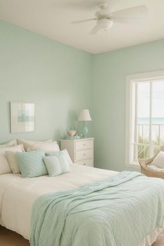 a bedroom with mint green walls and white furniture