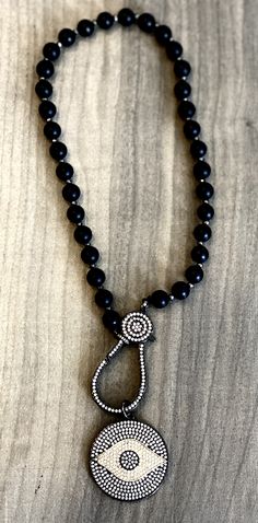 This is a black matte onyx crystal beaded choker necklace with an evil eye pendant. This necklace is boho style providing a protective barrier against harm. Features: Black beaded boho style Mix of onyx and crystal Length is 18 in. Weight is 1.7 oz Comes in a jewelry gift box. Evil Eye Spiritual, Eye Spiritual, Onyx Crystal, Eye Pendant, Evil Eye Pendant, Beaded Choker Necklace, Evil Eye Necklace, Black Matte, Beaded Choker