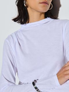 This effortlessly cool long sleeve tee will take you from day to night. Featuring a mock neck and draping throughout, with a universally flattering silhouette. (This one comes in White.) | Women's Charlotte Long Sleeve Top in White | Ethical Essentials Nation Ltd, Asymmetric Top, Sunday Dress, Asymmetric Neckline, Asymmetrical Tops, Sweater Blouse, White Top, White Long Sleeve, Classic White