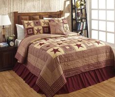 a bed with a brown and tan quilt on it in a room next to a window