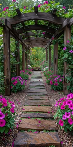 a garden with lots of flowers and plants growing on the sides of it's walkway