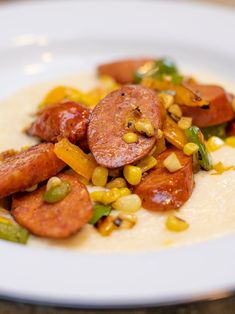 a white plate topped with corn and sausage