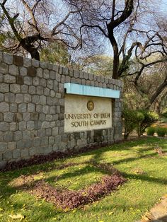 the university of british south campus sign is shown in front of a brick wall and trees