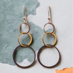 A little bit edgy, Amy is always at the peak of fashion perfection. Long interlocking tri-tone circles complete this minimalist look. Also available in short and medium lengths. Length: 1.75″ Finish: Oxidized Sterling Silver, Sterling Silver, 14K Gold Filled Mixed Metal perfect from everyday to eve earrings. Mom Ring, Mixed Metal Earrings, The Peak, Mixed Metals, Circles, Gold Filled, Sterling Silver, Ring, Silver