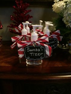 a bunch of soap bottles sitting on top of a table next to a christmas tree