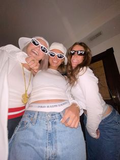 two women in white shirts and jeans posing for the camera