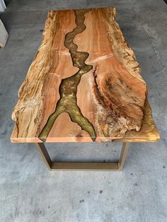 a table made out of wood with a river running through the center and two metal legs