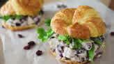 two chicken salad sandwiches on croissants with lettuce and raisins