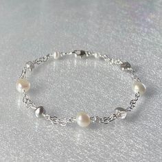 Premium-quality, white and gray freshwater pearl bracelet, handcrafted in sterling silver This versatile bracelet is designed with genuine, premium-quality, lustrous, 6mm baroque creamy-white pearls and small gray keshi freshwater pearls. These free-form pearls are evenly spaced along short segments of double-strand sterling silver chain. This bracelet is completed with a sterling silver lobster claw clasp.  Pearls are one of June's birthstones. Details: *  length: please choose at check-out gra Elegant Sterling Silver Hypoallergenic Pearl Bracelet, Silver Pearl Bracelet, Hand-strung, Nickel-free Sterling Silver Pearl Bracelet Gift, Adjustable Hand-strung White Pearl Bracelet, Nickel-free Sterling Silver Pearl Bracelet, Freshwater Pearl Jewelry, Freshwater Pearl Bracelet, Keshi Pearls, Bridesmaid Bracelet