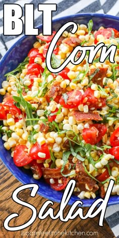 a blue bowl filled with corn salad on top of a wooden table