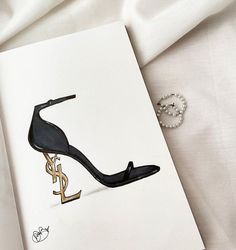 a drawing of a high heeled shoe on top of a white sheet next to a pair of earrings