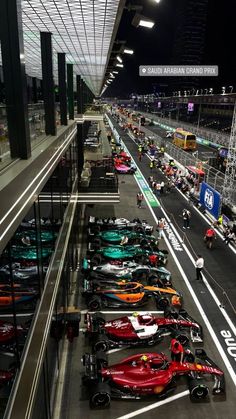 many cars are lined up on the track in an indoor race course at night time