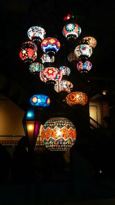 colorful lights hanging from the ceiling in a dark room