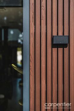 a close up of a wooden door with a black handle on the front and side