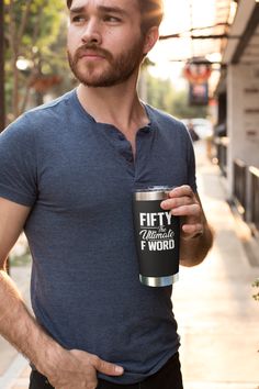 a man holding a coffee cup on the street