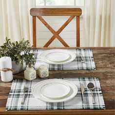 the table is set with white plates and silverware, along with a plaid placemat