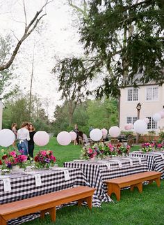 an outdoor party with black and white checkered tablecloths, paper lanterns and balloons