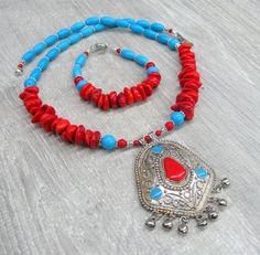 Red coral and Turquoise Southwestern necklace and bracelet set with Vintage Large silver enameled pendant. Necklace: The central part is a Vintage Tribal silver tone pendant made in India - textured pendant with turquoise blue and red enamel and 7 metal dangles. The necklace is made of natural red coral beads ( irregular shape ), blue turquoise howlite, round red pressed stone beads and silver plated diasy spacers. Bead size: - coral chips approximately 10 - 12 mm wide and 3 - 6 mm thick, - roun Red Southwestern Style Jewelry Gift, Southwestern Style Red Jewelry For Gifts, Southwestern Style Red Jewelry For Gift, Red Southwestern Turquoise Necklace For Gift, Red Large Pendant Jewelry For Festival, Red Jewelry With Large Pendant For Festivals, Southwestern Red Festival Jewelry, Southwestern Style Red Festival Jewelry, Southwestern Style Red Necklace For Gift