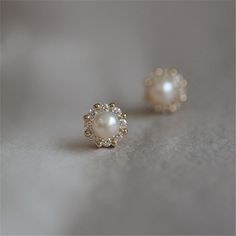 Simple and timeless. Every girl needs a pair of classic pearl studs in their jewelry box! This pair has a modern twist, with a 14K gold or silver halo of alternating CZ stones and shiny beads surrounding a gorgeous faux pearl. DETAILS & SIZE Sold as a pair Composition: 14K gold plated over .925 sterling silver or solid .925 sterling silver; CZ stones; faux pearl Measurements: 7mm Comes with friction earring backs Read about how to care for your jewelry here. Shop the Ear Bar to curate your ear s Small Earrings Gold, Top Earrings, Stud Earrings Women, Silver Pearl Earrings, Simple Pearl, Indian Gowns, Fashion Enthusiast, Jewelry Simple, Gold Earrings Designs