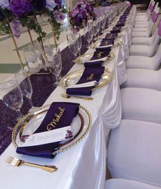 the table is set with purple napkins and place settings for guests to sit at