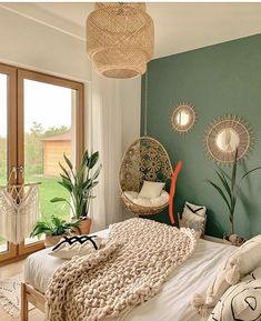 a bedroom with green walls and white bedding, hanging planters on the wall