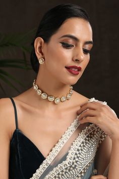 This choker necklace set is an edgy piece with a geometrical deisgn. The timeless kundan in a backdrop of glorious gold plated silver alloy is a very pretty modern piece. Necklace Closure - Adjustable Dori Earrings Closure - Push Back Style Tip - Versatility and elegance being the strong suit, we leave a lot to your imagination for how you want to dress your jewels your way and embracing your personal style. This pretty is made for a modern day woman who has her heart in the little details of he Diwali Reception Choker Jewelry, Diwali Reception Choker, Reception Kundan Choker Necklace, Meenakari Choker Necklaces For Parties, Gold Choker With Jewels For Celebrations, Gold Jeweled Choker For Celebrations, Festive Gold Choker With Jewels, Festive Gold Jeweled Choker, Festive Metal Choker For Celebrations