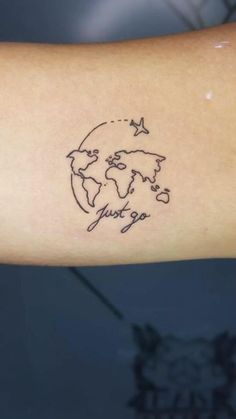 a person with a tattoo on their arm that says just go and an airplane flying around the world