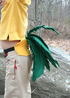 a young boy wearing a costume made to look like a palm tree is standing on a rock